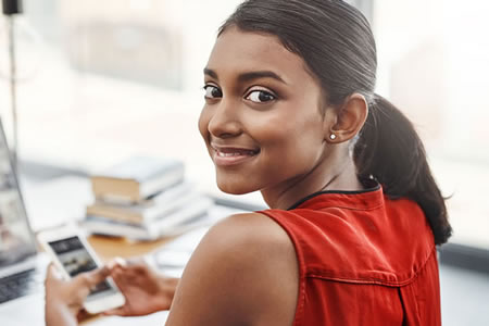 woman at desk using a mobile phone